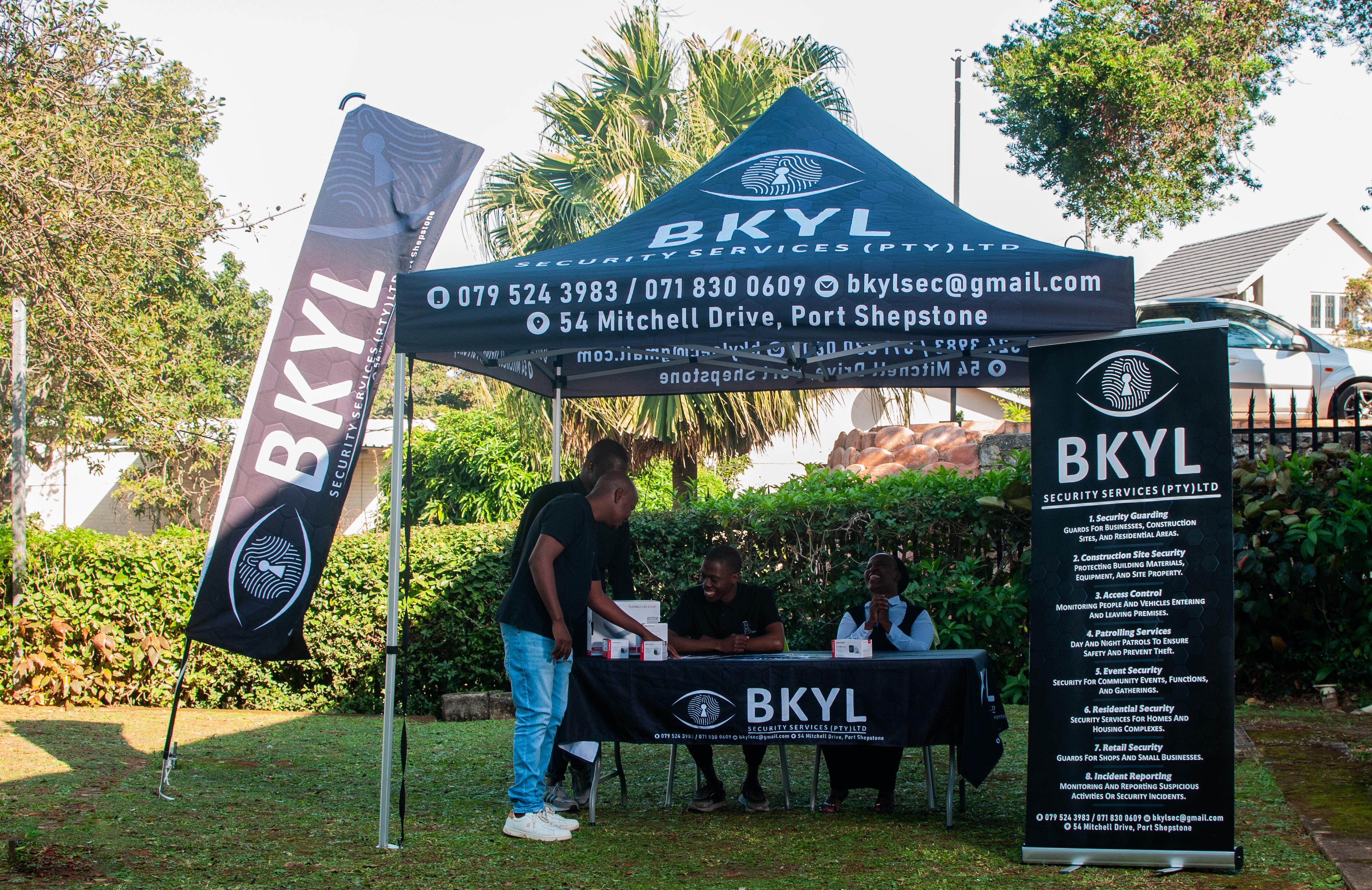 BKYL team lined up in front of branded tent